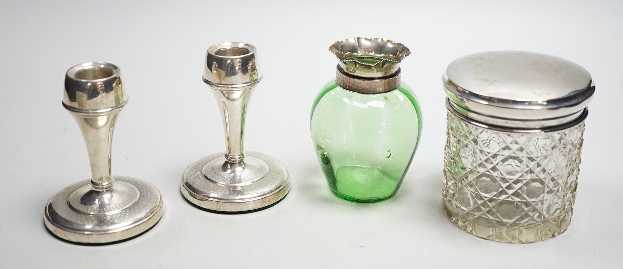A pair of mid 20th century silver mounted dwarf candlesticks, 92mm, a silver mounted glass jar and a green glass vase.                                                                                                      