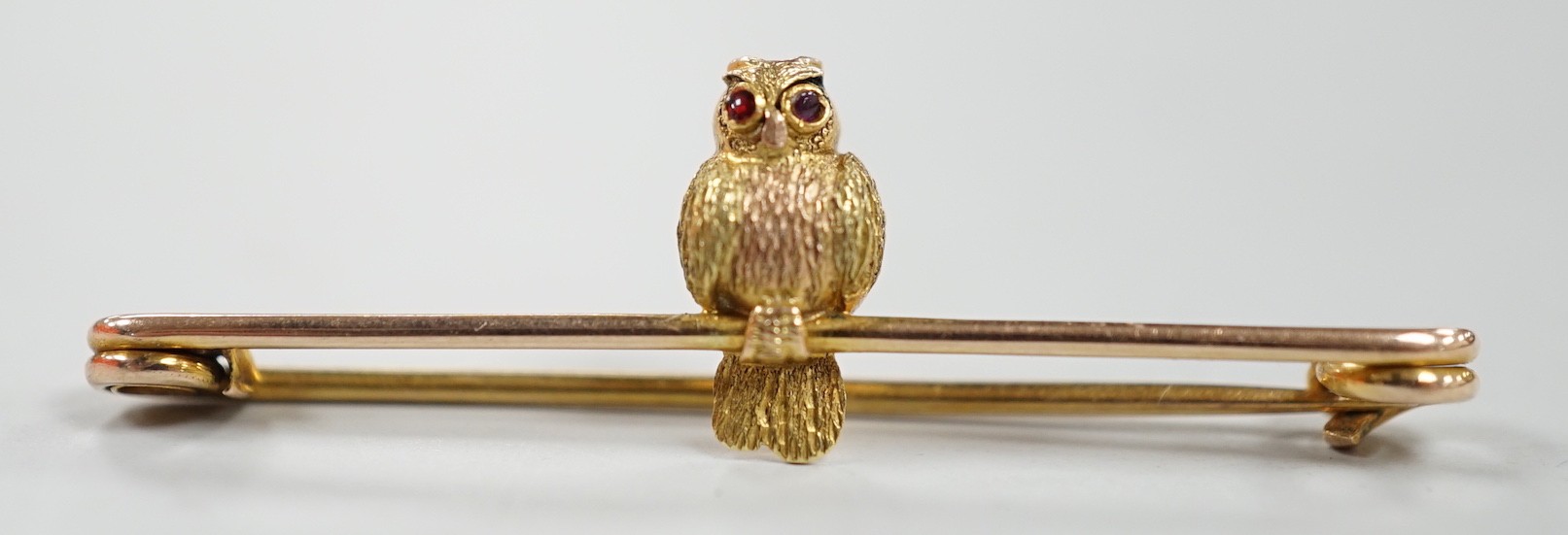 A mid 20th century two colour 9ct owl bar brooch, with cabochon eyes, 38mm, gross weight 1.3 grams.                                                                                                                         