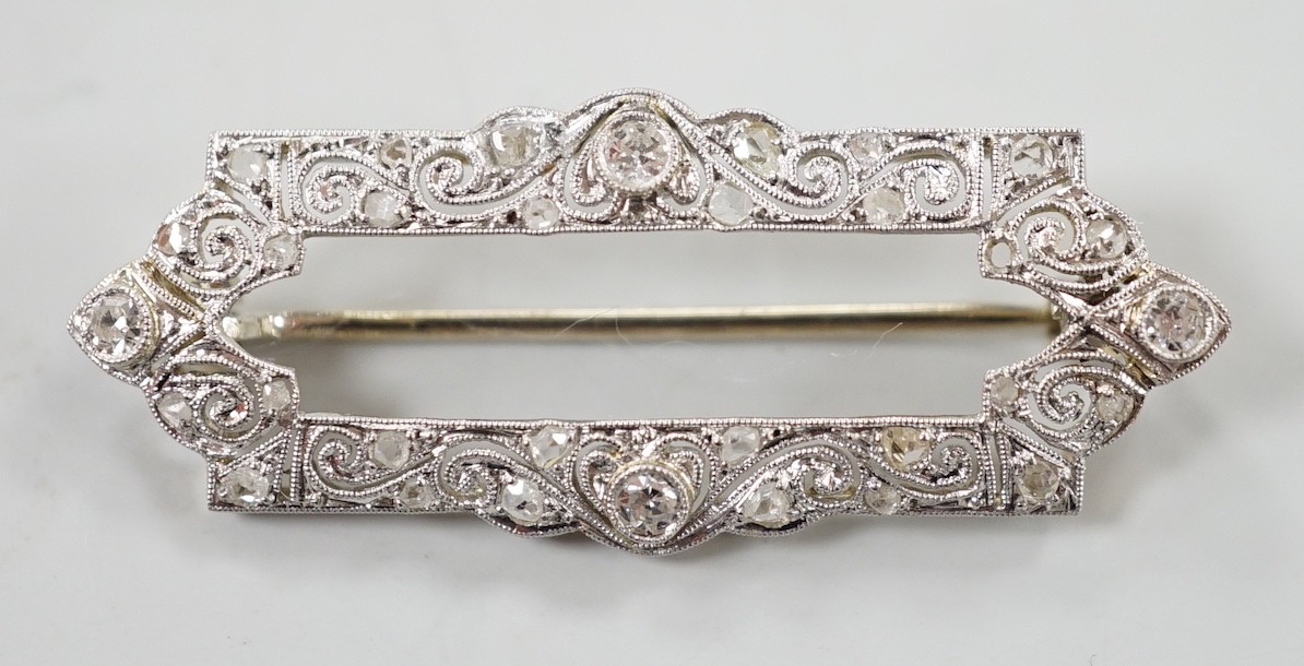 A 1940's/1950's pierced yellow metal and millegrain set round and rose cut diamond open work brooch, 33mm, gross weight 2.7 grams.                                                                                          