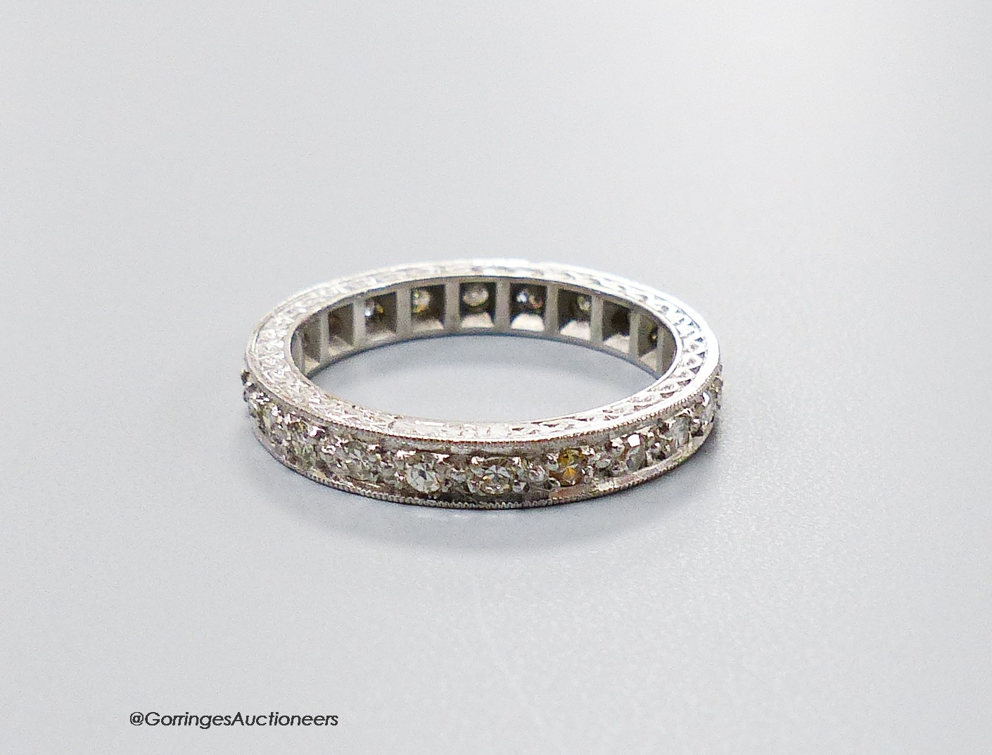 A mid 20th century white metal (stamped 18ct) and diamond set full eternity ring, size M, gross weight 4.8 grams.                                                                                                           