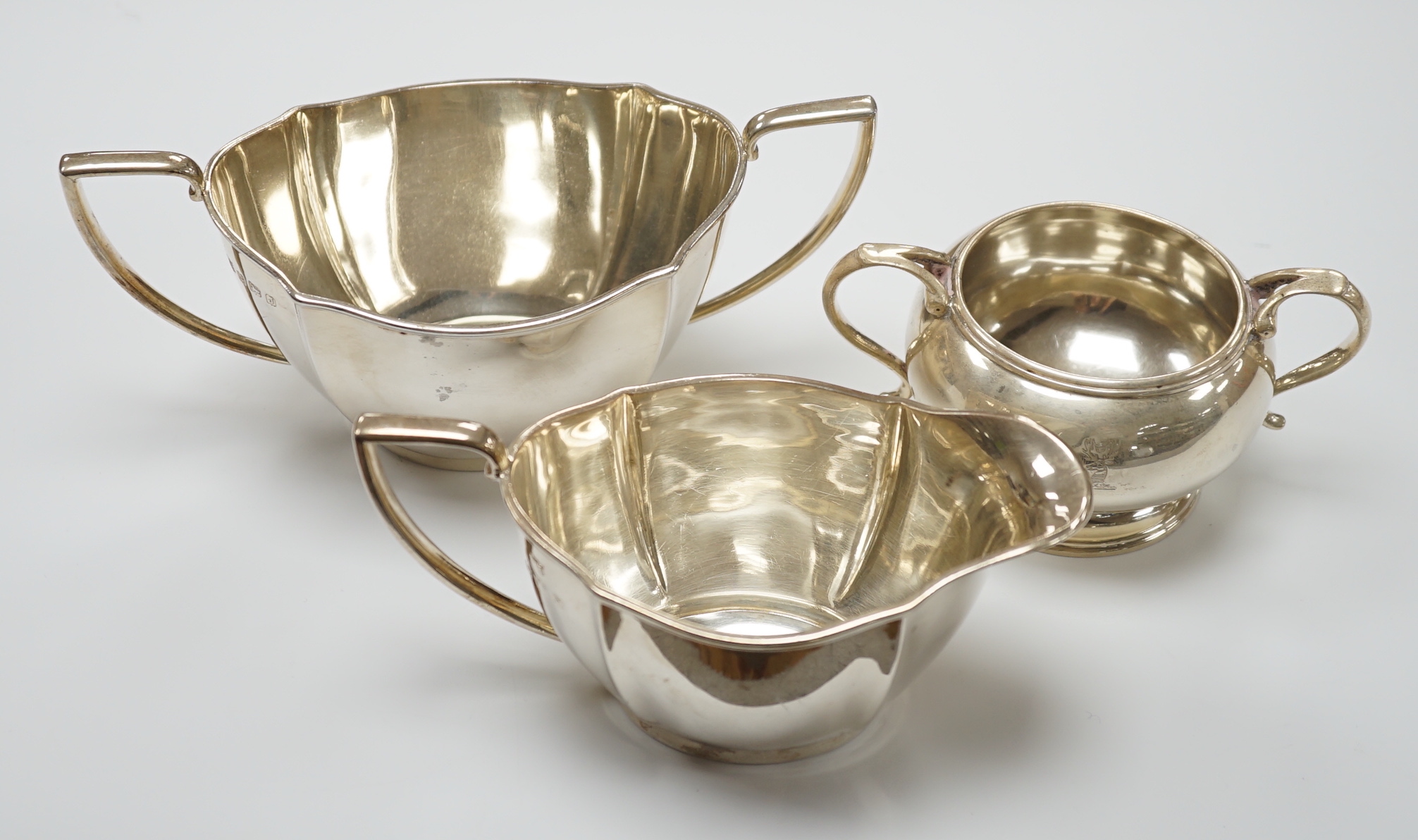 A George V silver sugar bowl and cream jug, Barker Brothers Silver Co, Birmingham, 1933 & 1937 and one other silver sugar bowl, 18.3oz.                                                                                     