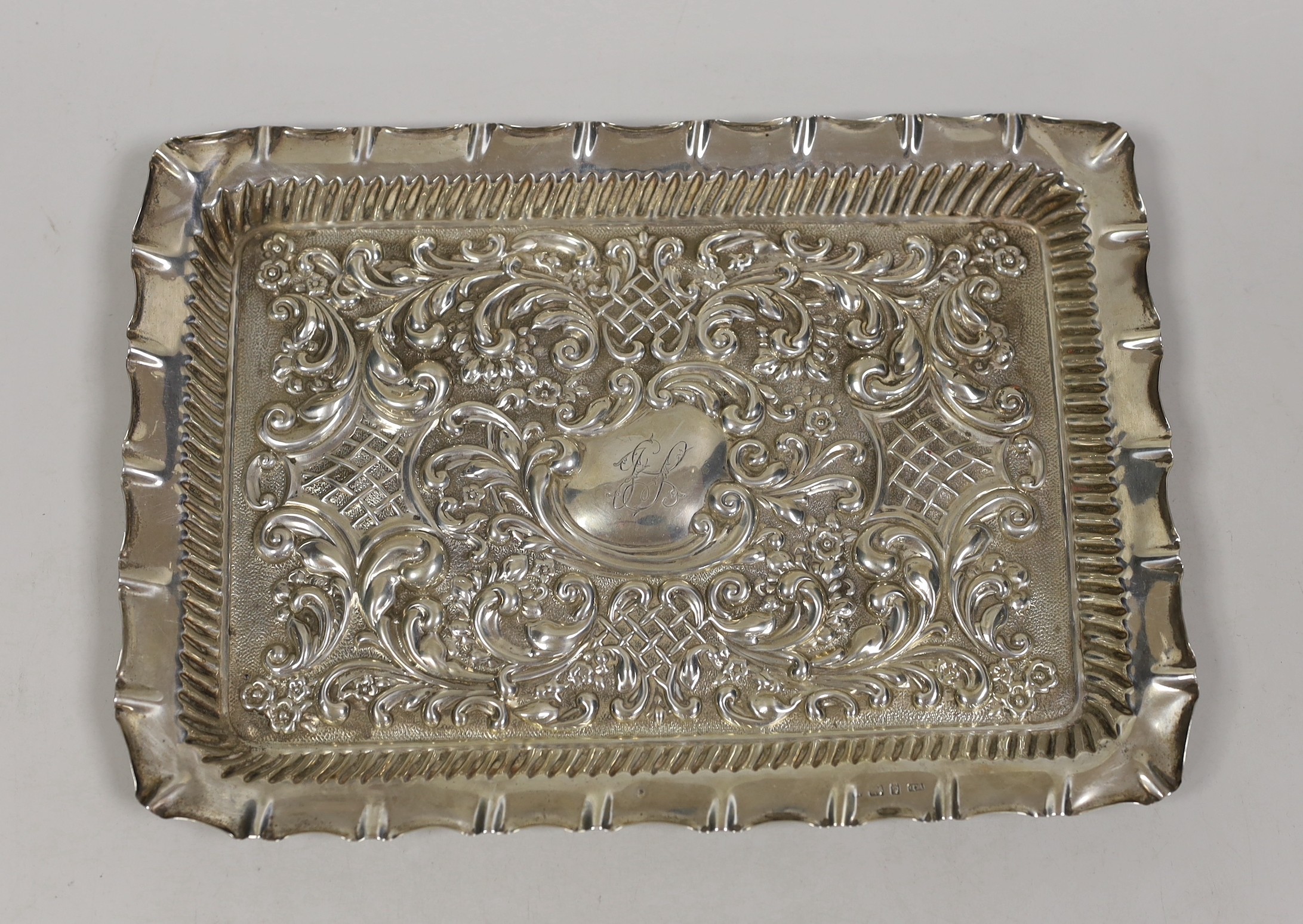 An Edwardian? repousse silver dressing table tray, maker, William Davenport, Birmingham, circa 1905, 27.2cm, 8.7oz.                                                                                                         