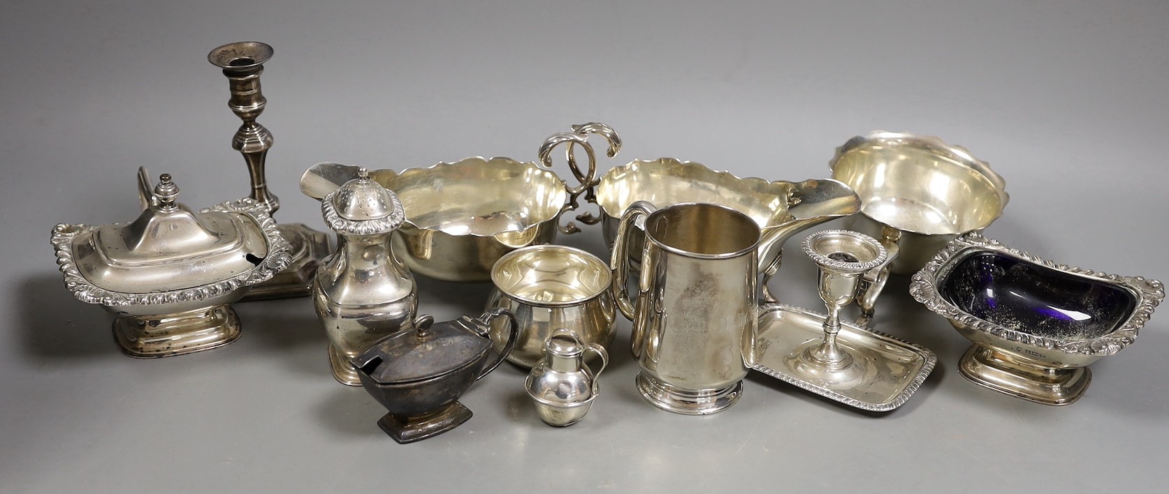 A pair of late Victorian silver sauceboats, Frederick Augustus Burridge, London, 1899, a George V silver mounted taperstick, a modern silver three piece condiment set, a silver chamberstick, silver mug, two silver small 