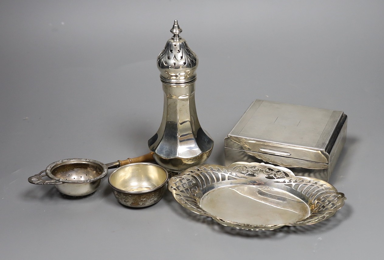 A George V engine turned silver mounted cigarette box, a similar sugar caster and later silver tea strainer and small dish.                                                                                                 
