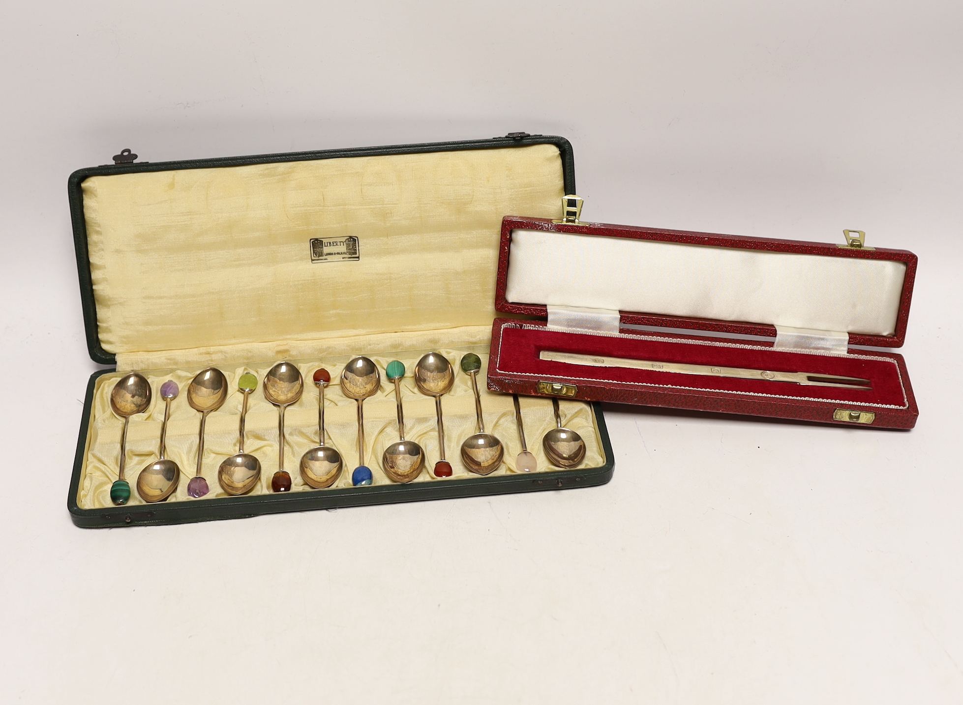 A cased set of twelve George V Liberty & Co silver coffee spoons, with gem set terminals including amethyst, malachite and carnelian, Birmingham, 1927, 93mm, in Liberty & Co box.                                          