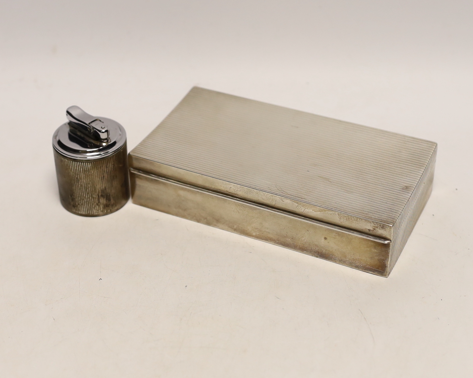 A sterling 925 mounted rectangular cigarette box, with reeded cover, 17.4cm and a similar unmarked cigarette lighter.                                                                                                       