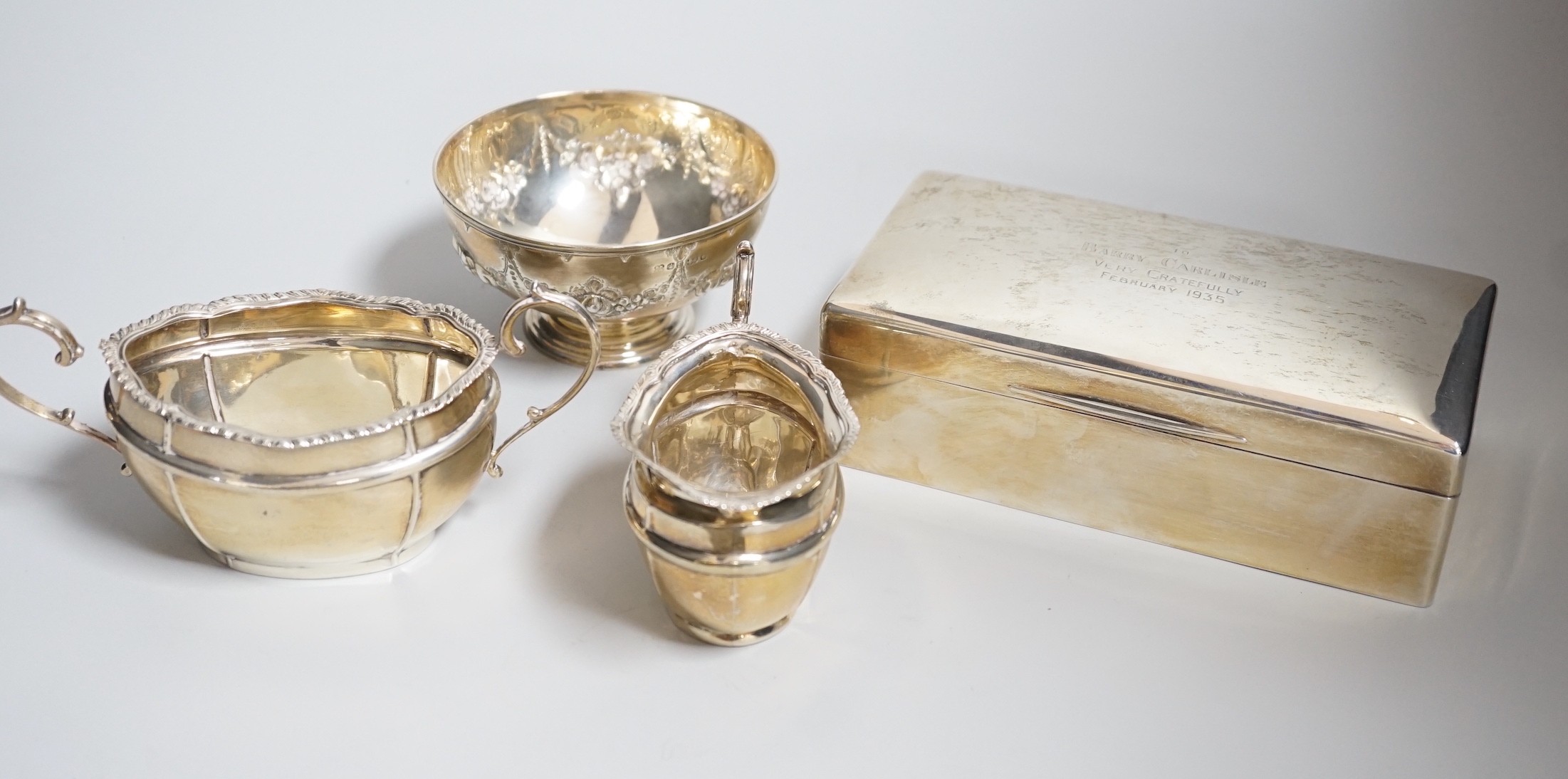 A George V silver milk jug and sugar bowl, London, 1917, a silver mounted cigarette box and a small silver bowl.                                                                                                            