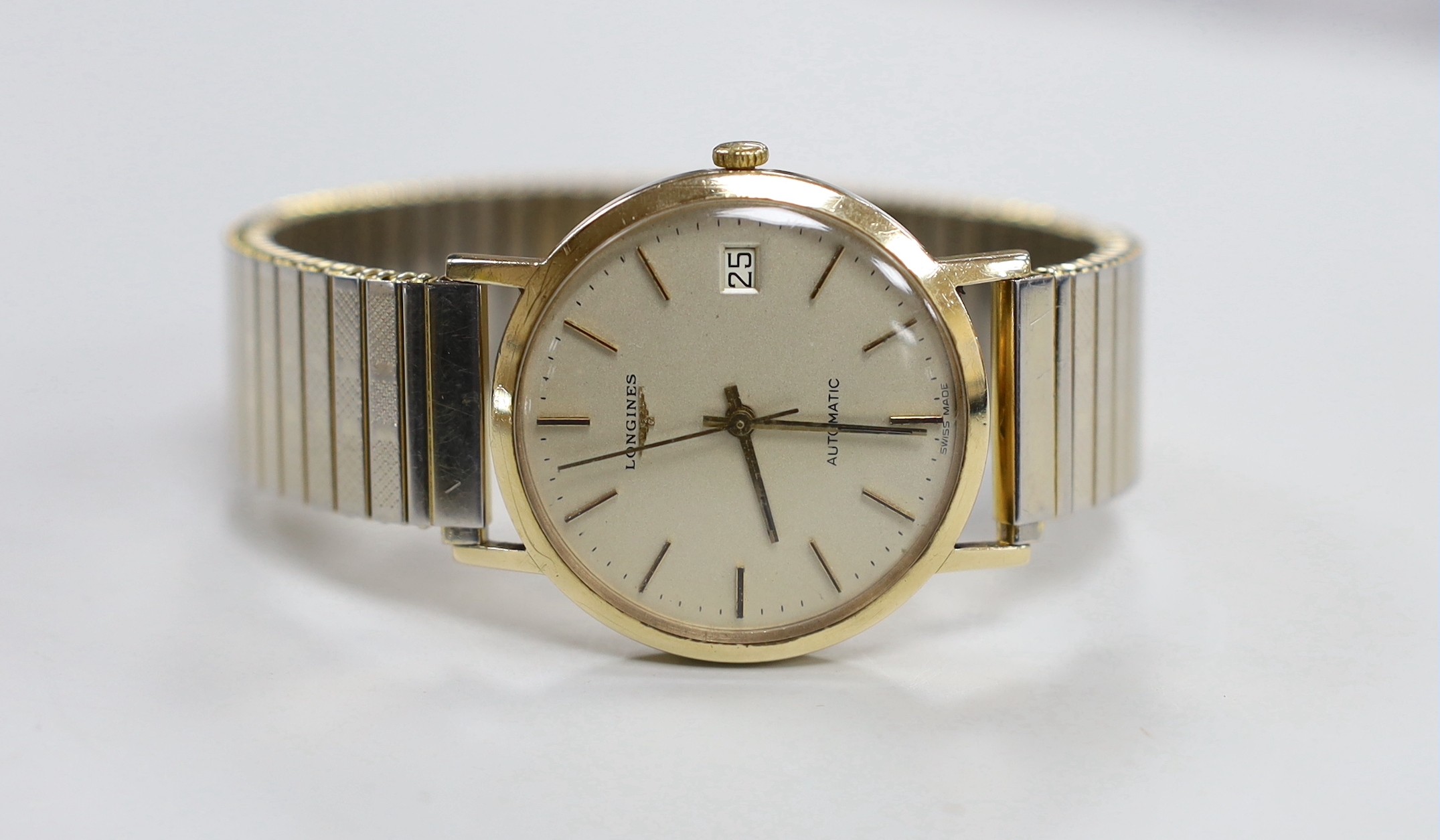 A gentleman's 9ct gold Longines automatic wrist watch, with date aperture, on associated gold plated bracelet, case diameter 35mm.                                                                                          