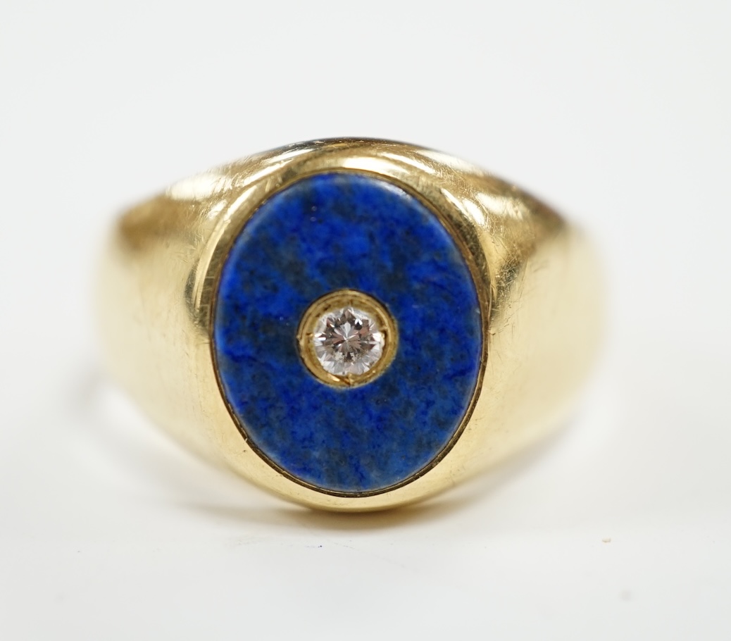 A mid to late 20th century Italian 750 yellow metal and oval lapis lazuli set signet ring, with inset diamond, size U, gross weight 12 grams.                                                                               