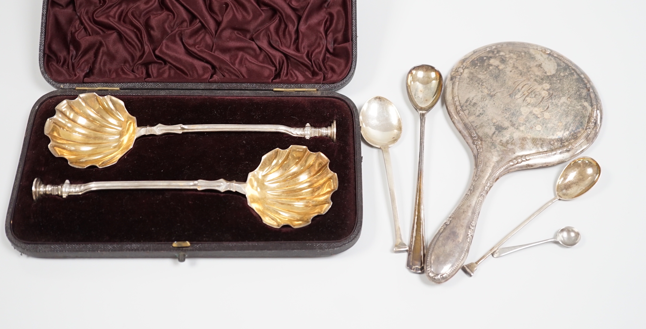 A cased pair of Victorian silver seal top serving spoons, Francis Higgins, London, 1887, 21.5cm, four other sundry silver spoons and a silver mounted hand mirror.                                                          