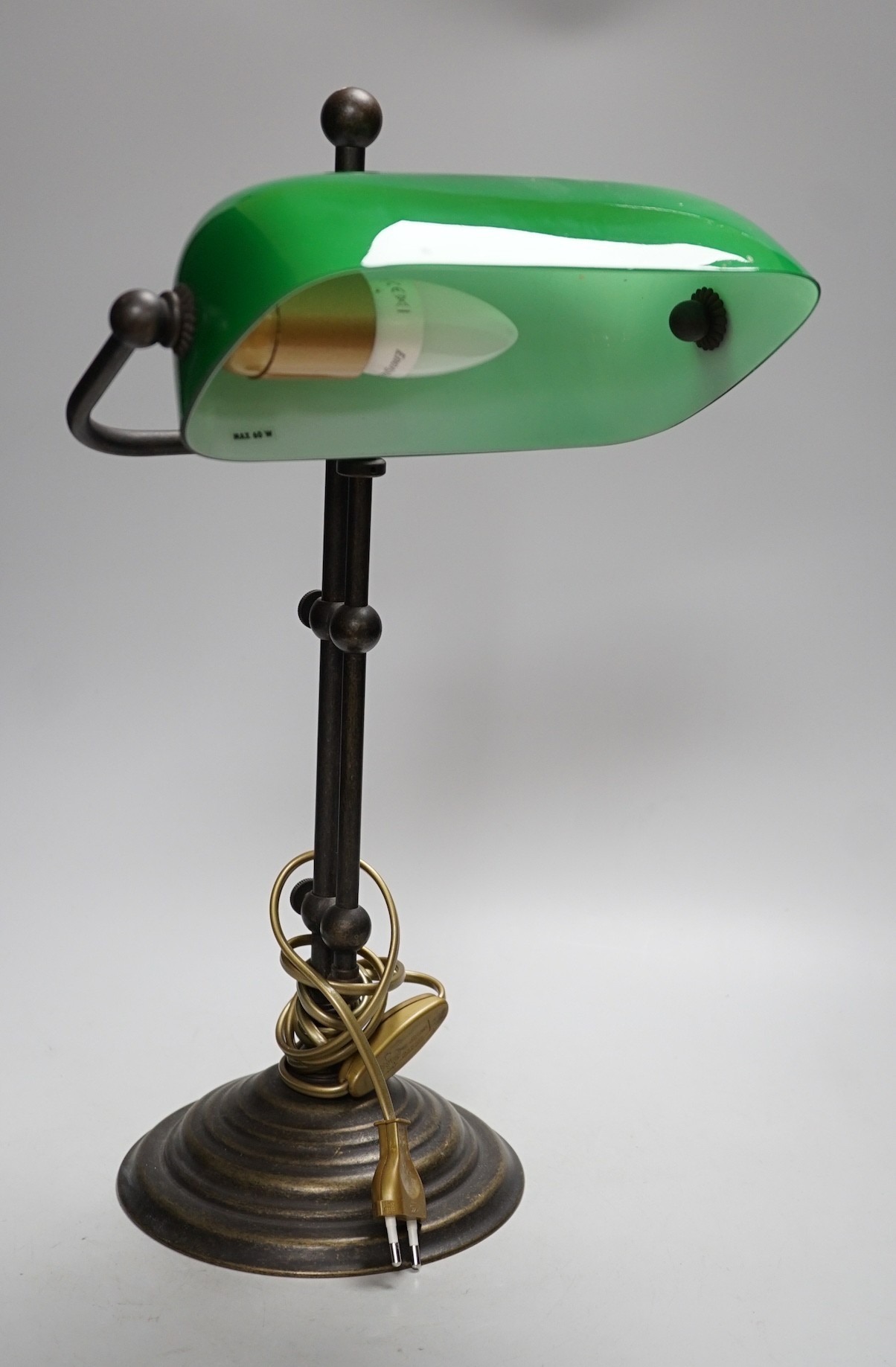 A green glass and brass student lamp, 48cms high                                                                                                                                                                            