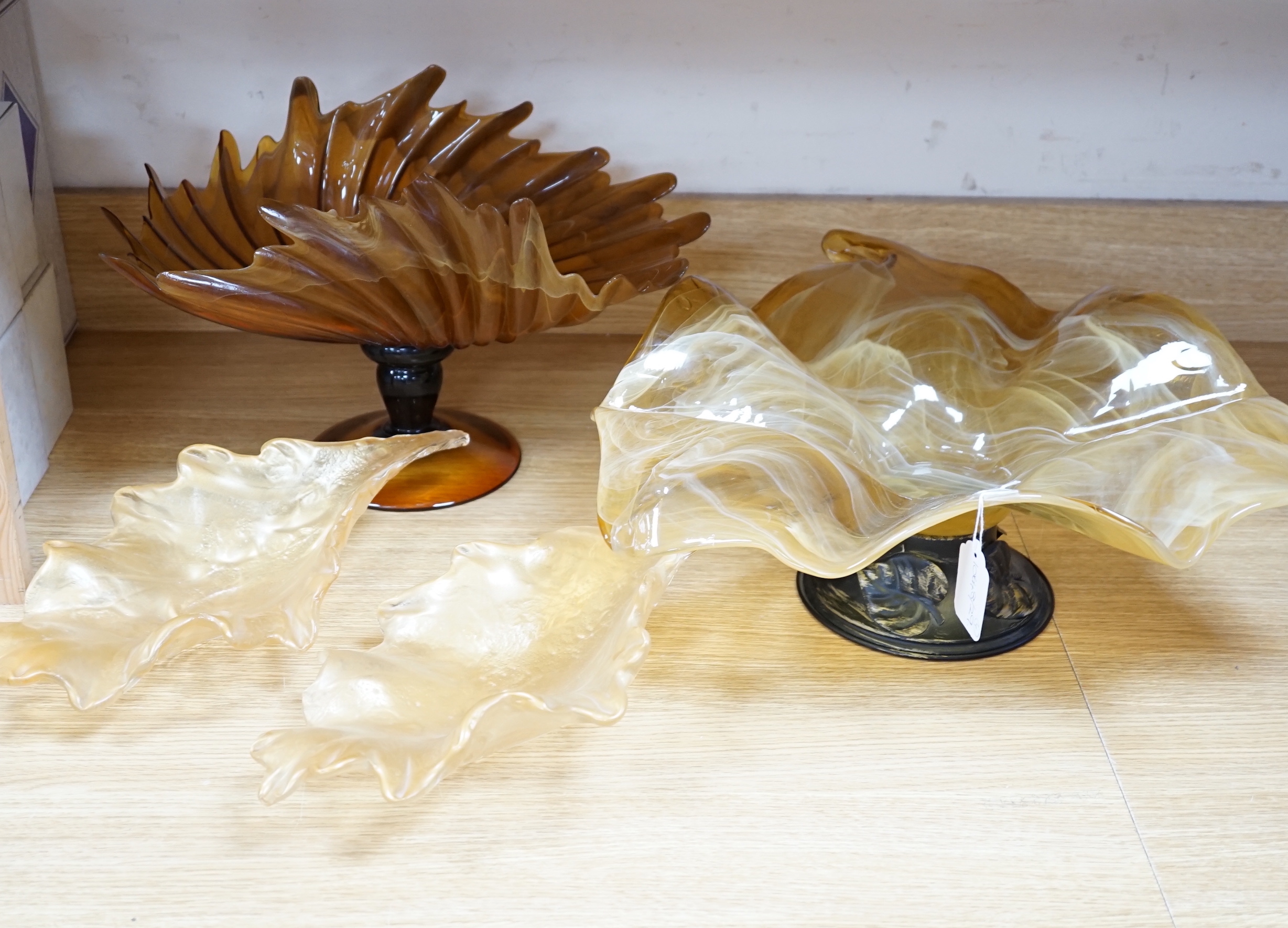 Two amber glass frilled table centrepieces, one with Murano label to the base and a pair of similar leaf shaped dishes (4), the largest 48cm wide                                                                           