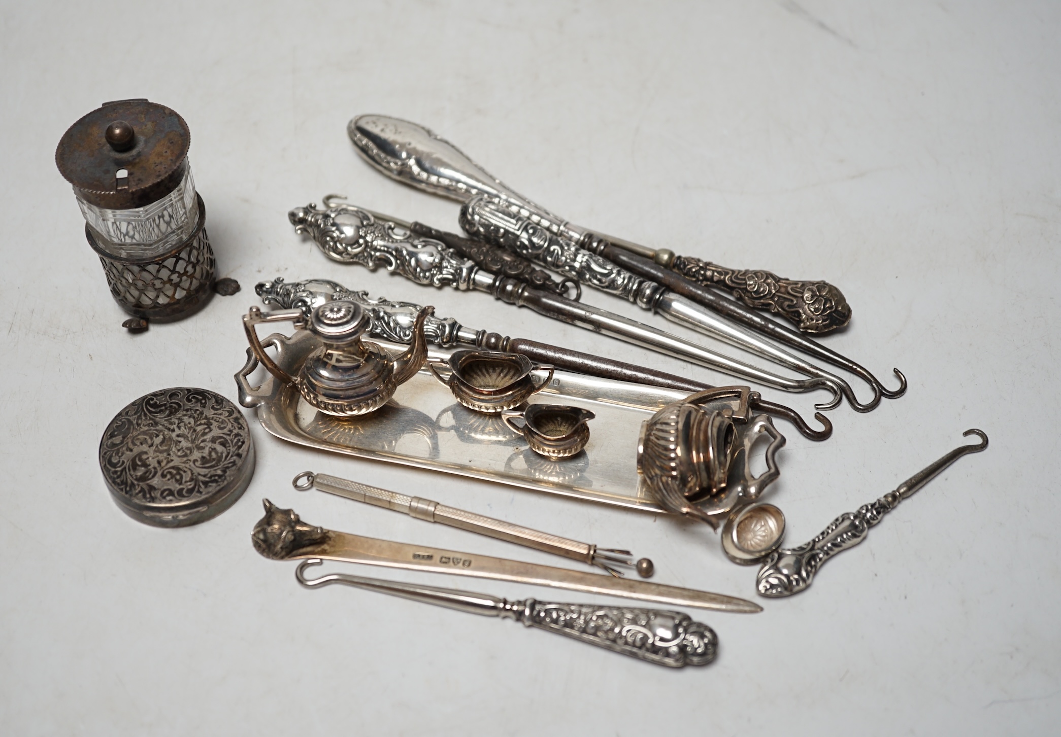 Sundry silver including a 1970's miniature four piece tea set and tray, a George III silver caddy spoon, Edwardian letter opener with fox head terminal, swizzle stick, button hooks etc. Condition - poor to fair          