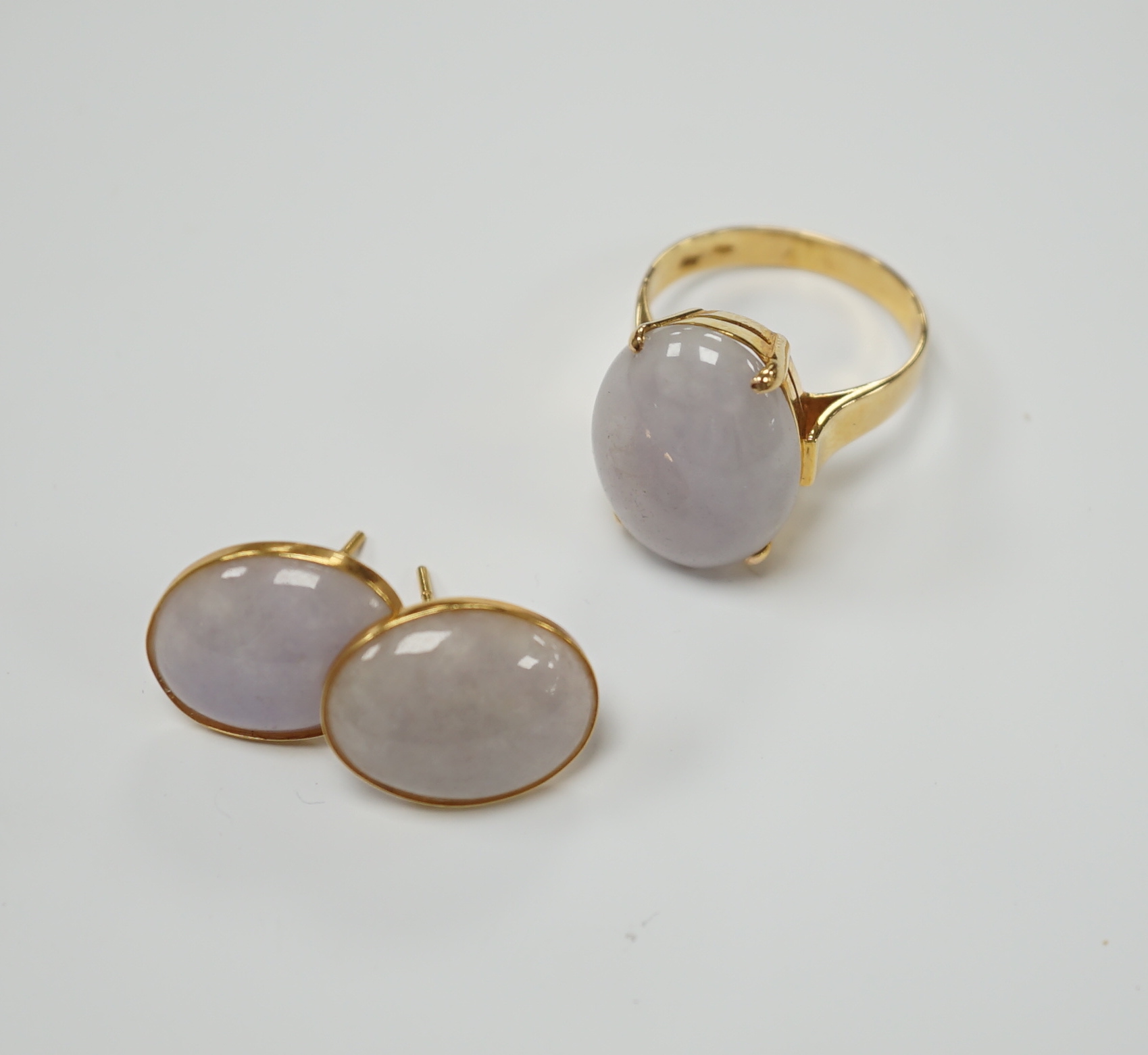 A 14k yellow metal and oval white cabochon jade set ring, size M/N and pair of matching earrings, gross weight 9.7 grams.                                                                                                   