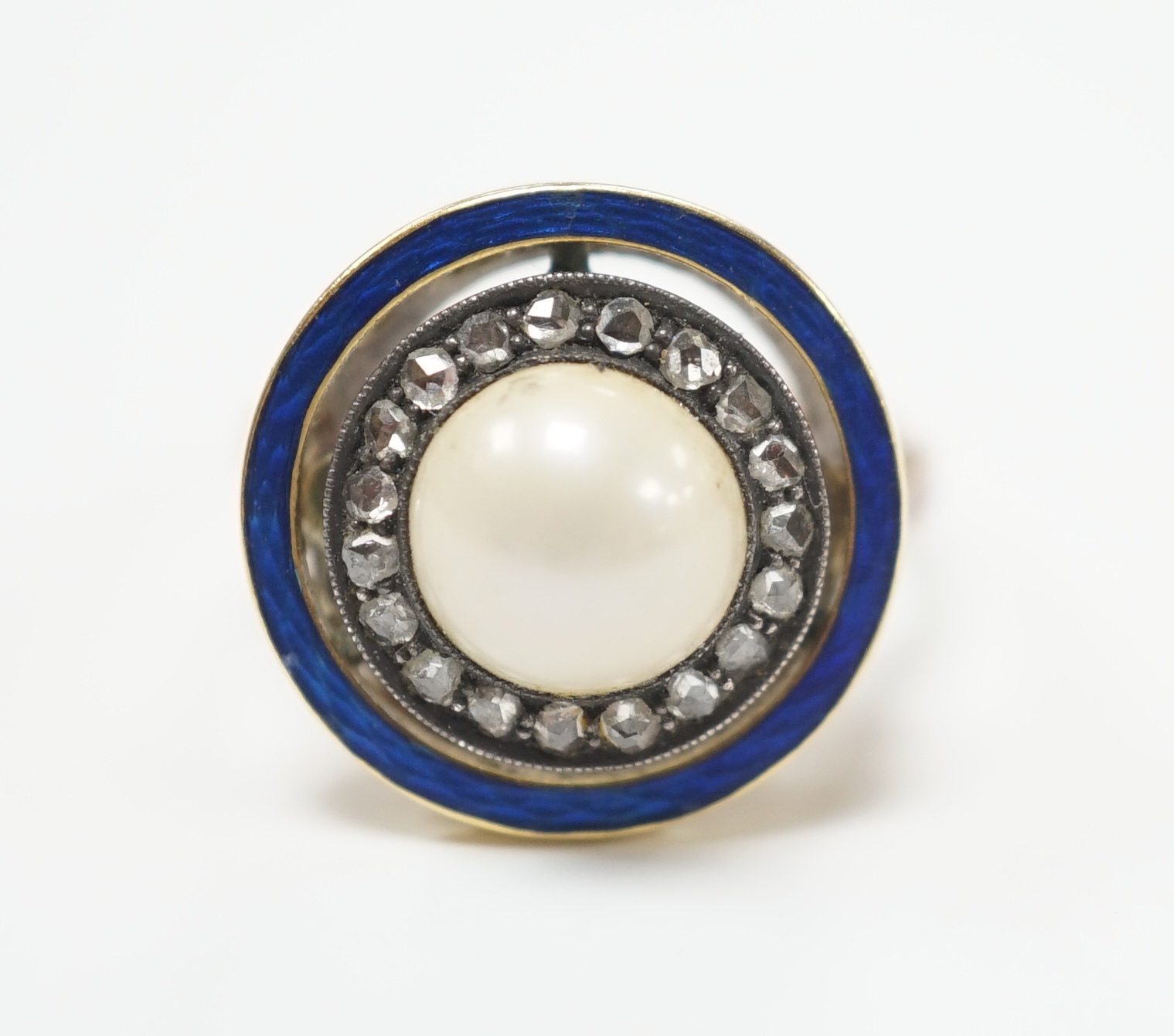 An early to mid 20th century yellow metal, split pearl, rose cut diamond chip and blue enamel set target ring, size H, ross weight 4.6 grams.                                                                               